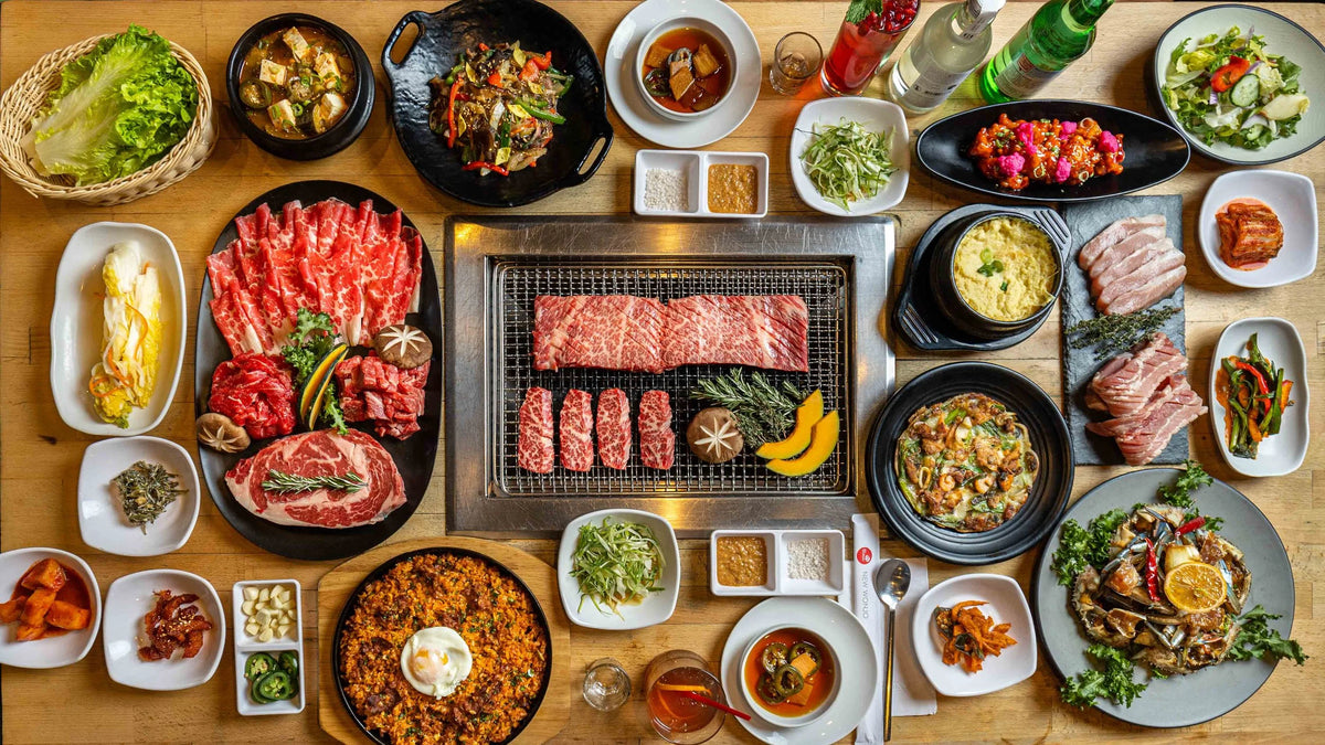 A Korean barbecue table spread with side dishes